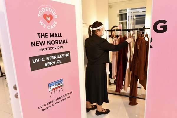 商場工作人員在UV- C消毒間準備對衣物進行消毒