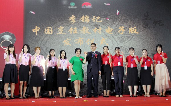 陳姝（中左）與王會昌（中右）向志愿者代表贈送李錦記電子教材熊貓U盤